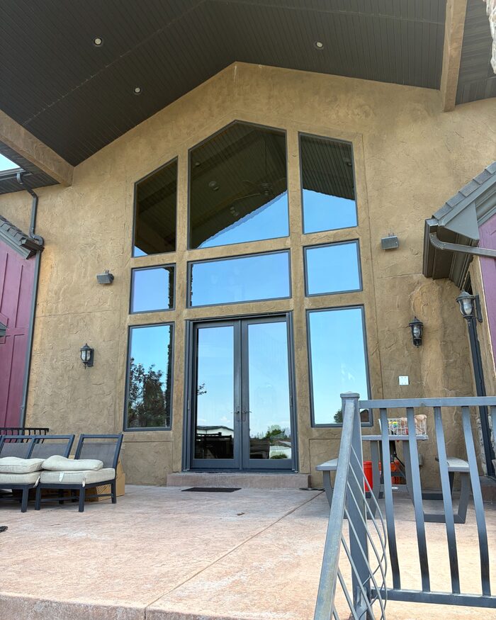Finished exterior windows across a tall patio wall.