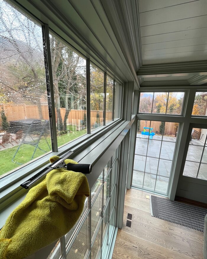 A squeegee and microfiber towel resting on the sill during window cleaning.